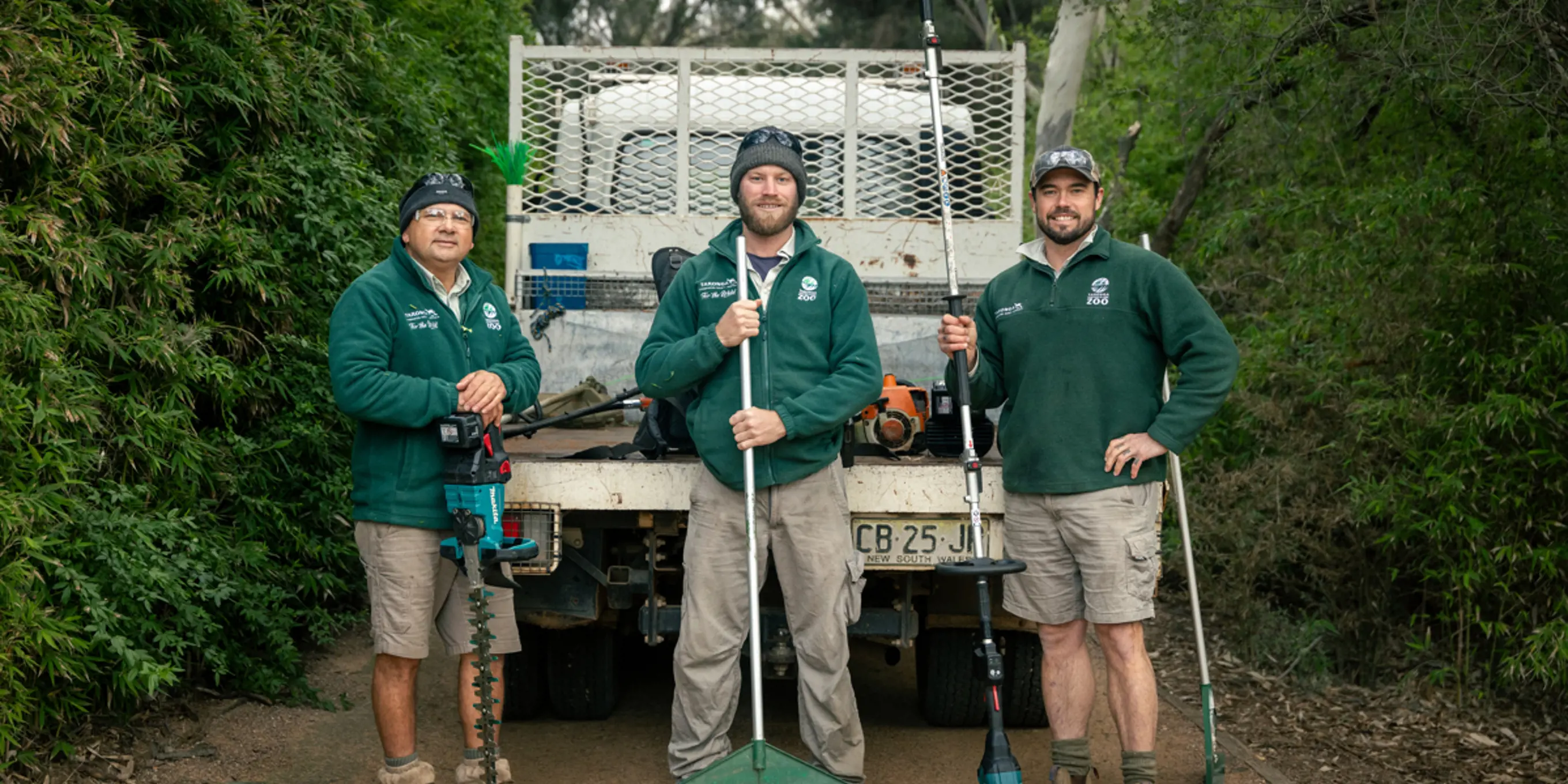 Three gardeners with equipment in front of van in Dubbo Zoo