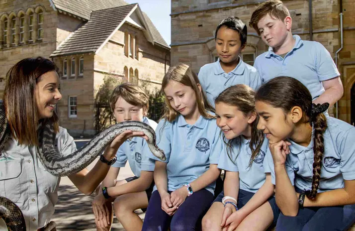 School students observing a snake during a Zoomobile wildlife education session.