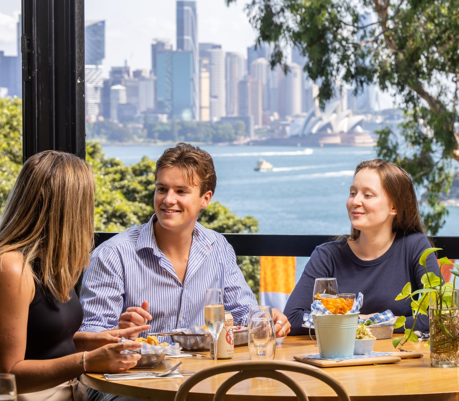 Guests dining at Saltwater Bistro with views across Sydney Harbour to the Opera House.