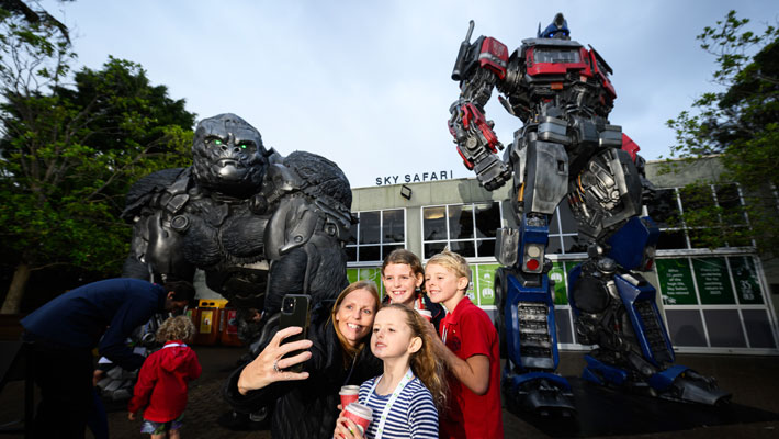 Family taking a selfie with the life-sized Transformers Statues