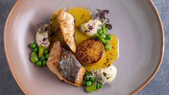 Pan-seared Sea Bass w/ artichoke cream, mountain pepperberry marinated edamame & green peas, daikon fondant & lemon myrtle butter sauce.